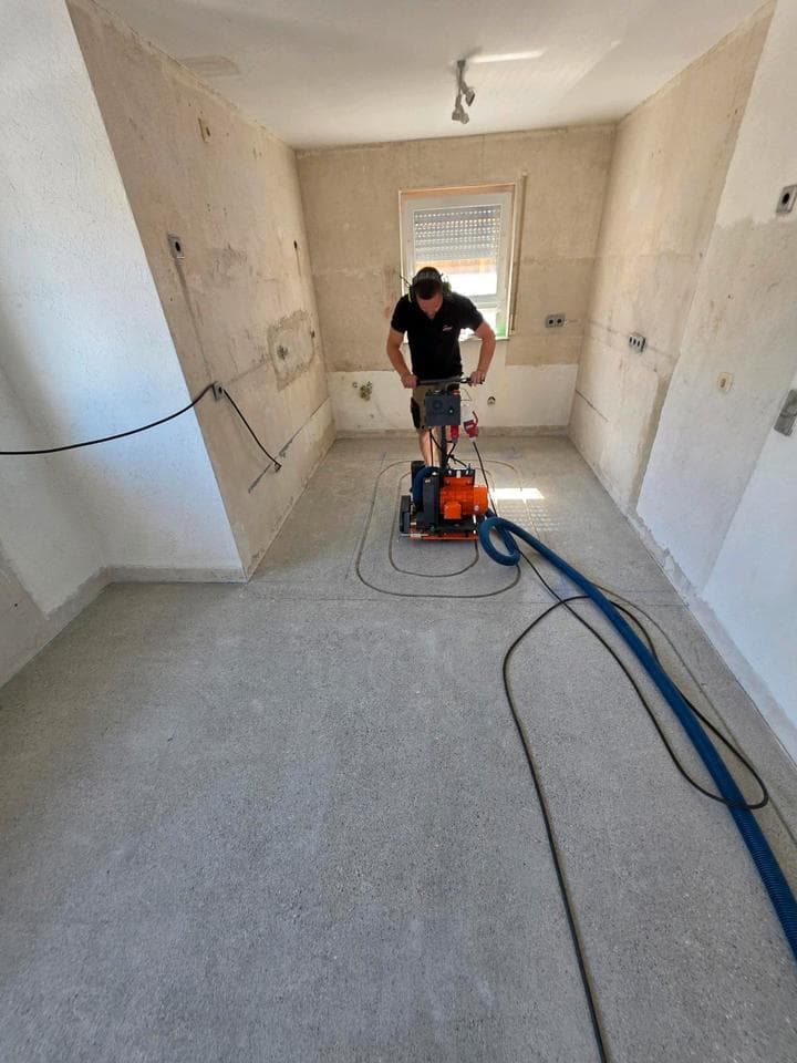 Fräsmaschine im Einsatz: Kanäle für die Fußbodenheizung werden in den Estrich gefräst
